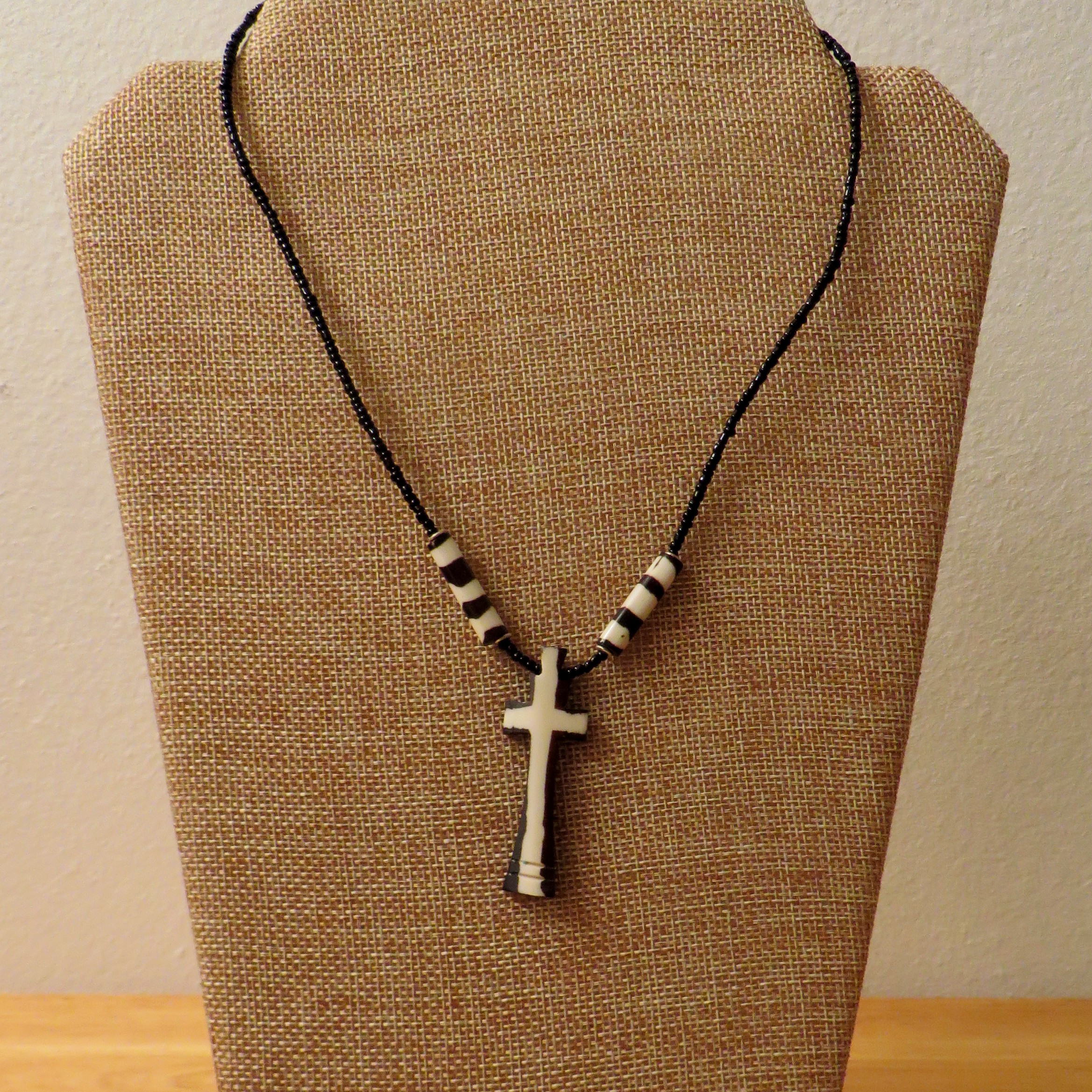 cross necklace with one colored bead